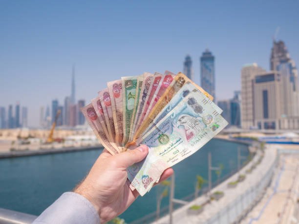 a man holds the money of the united arab emirates. dirham