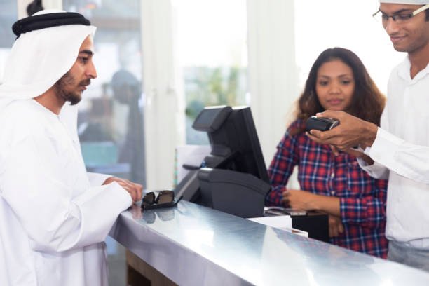 arab paying for his meal at the register via cashless payment.