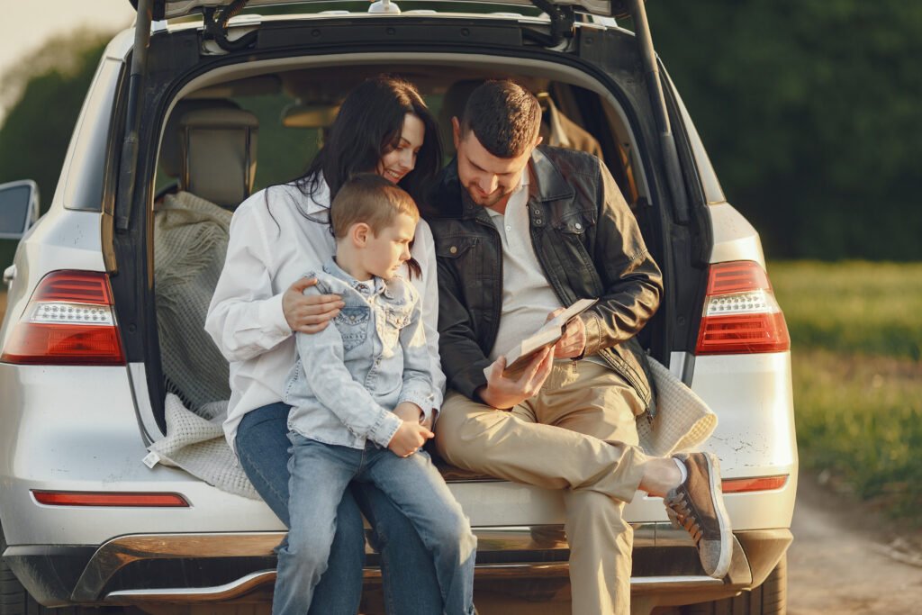 family in a summer forest by the open trunk